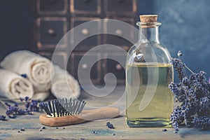 Bottle of natural cosmetic lavender oil, hair and body treatment, with a wooden massage comb