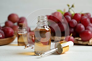 Bottle of natural grape seed oil on white table. Organic cosmetic