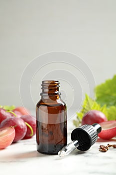 Bottle of natural grape seed oil on white table. Organic cosmetic