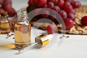 Bottle of natural grape seed oil on wooden table. Organic cosmetic