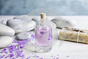 Bottle with natural herbal oil, soap and lavender flowers