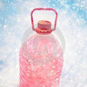 Bottle with non-freezing windshield washer fluid, snowflakes background