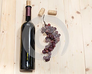 Bottle of old wine, sear grape and corks on wooden