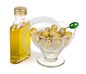 Bottle of olive oil with green olives watered with oil photo
