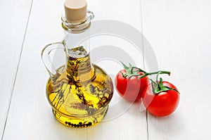 Bottle of olive oil with herbs and two red tomatoes