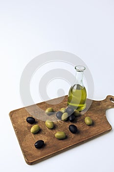 Bottle of olive oil and olives on board