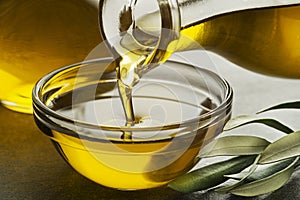 Bottle of Olive oil pouring in glass