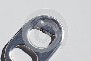 the bottle opener from the iron can of the drink is on the table macro photo blurred background