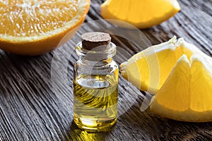 A bottle of orange essential oil on a wooden table