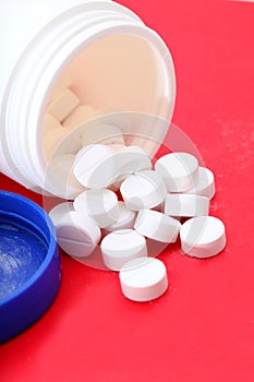 Bottle of paracetamol on red tablets.