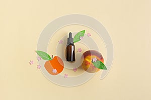 Bottle of peach essential oil flatlay concept with leaves and littles flowers cut from paper and