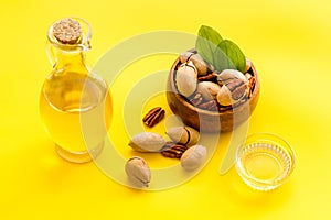 Bottle of pecan oil with nuts on the table, close up