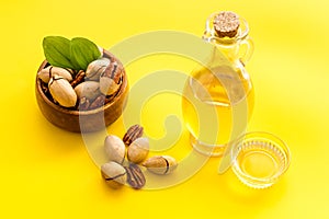 Bottle of pecan oil with nuts on the table, close up
