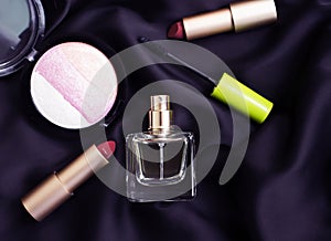 Bottle of perfume, decorative cosmetics on a silk background