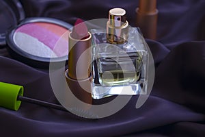 Bottle of perfume, glass  decorative cosmetics on a silk background