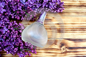 A bottle of perfume on a table against a lilac background