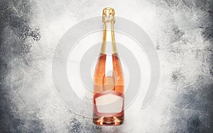 Bottle with pink sparkling wine or rose champagne and glasses, gray background with place for text, holiday or date concept, flat