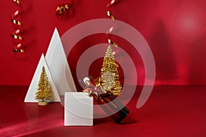 Bottle with Pipettes Cosmetic Products White Geometric Pedestals Golden Small Christmas Tree and Golden Ribbon Red Background