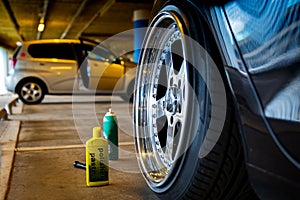 A bottle of polishing paste next to a perfectly polished car disc