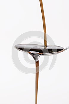 Bottle pouring a liquid on a spoon. Isolated on a white background. Pharmacy and healthy background. Medicine. Cough and cold drug