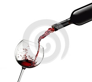 Bottle pouring red wine in glass with splashes