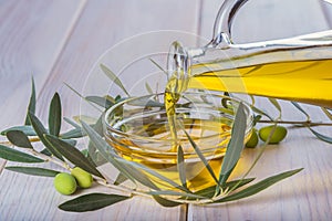 Bottle pouring virgin extra olive oil in a bowl