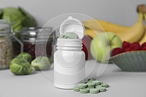 Bottle of prebiotic pills and food on grey table