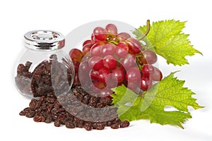 A bottle of raisins with red grapes