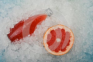 Bottle of red grapefruit drink on ice