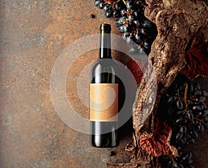 Bottle of red wine with blue grapes on a rusty background