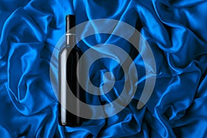 Bottle of red wine on a blue satin background