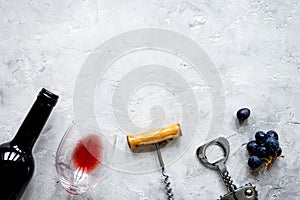 Bottle of red wine and corkscrew on stone background top view mo