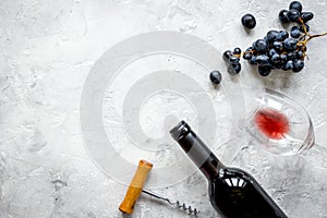 Bottle of red wine and corkscrew on stone background top view mo