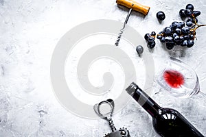 Bottle of red wine and corkscrew on stone background top view mockup