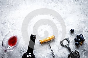 Bottle of red wine and corkscrew on stone background top view mockup