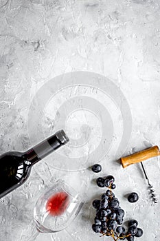 Bottle of red wine and corkscrew on stone background top view mockup