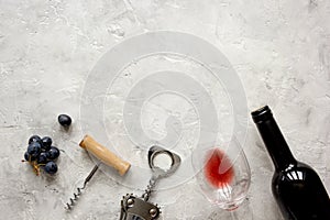 Bottle of red wine and corkscrew on stone background top view mockup