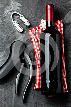 Bottle of red wine with corksrew on slate background. Top view photo