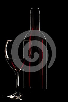 Bottle of red wine with a glass