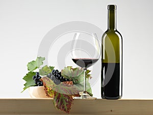 Bottle red wine, glass, grapes white background