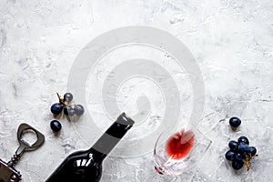 Bottle of red wine with grapes on texture background top view mo