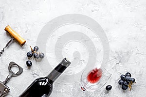 Bottle of red wine with grapes on texture background top view mo