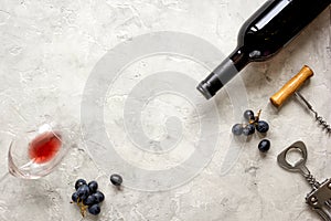 Bottle of red wine with grapes on texture background top view mock-up