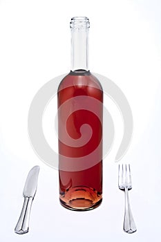 Bottle of red wine with knife and fork