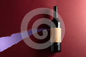 Bottle of red wine with old empty label on a dark red background