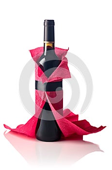 Bottle of red wine wrapped in crepe paper isolated on a white background