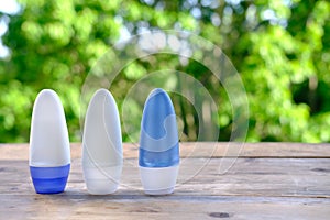 Bottle for roll-on deodorant antiperspirant ergonomically shaped wooden on table in garden, beautiful blurred natural background