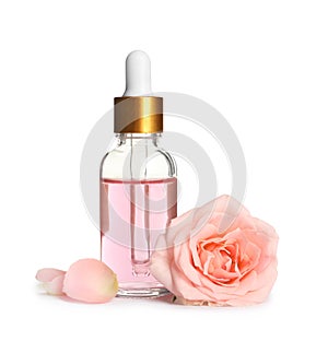 Bottle of rose essential oil and flower on white