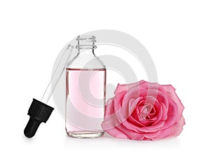 Bottle of rose essential oil, pipette and flower