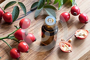 A bottle of rose hip seed oil on a wooden table